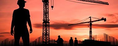construction site with cranes in silhouette